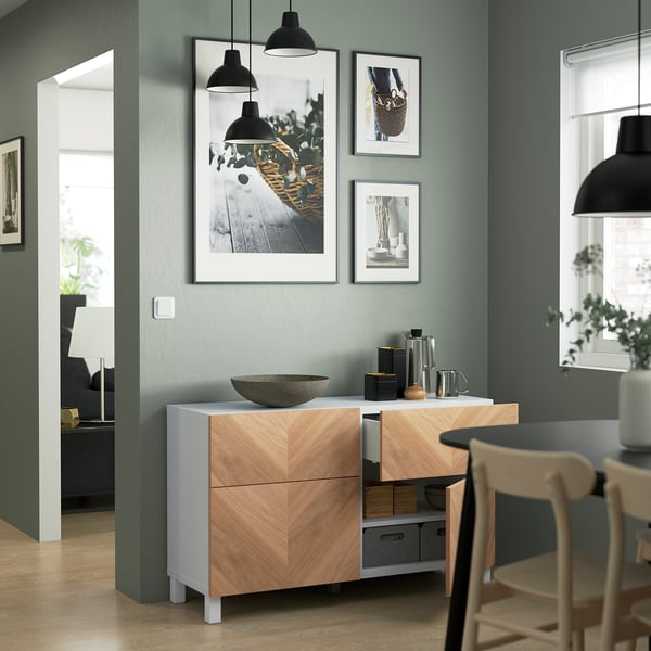A modern sideboard with shelves and drawers, featuring wall-mounted photos above it.