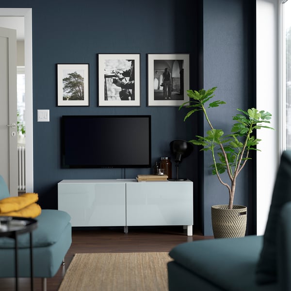 Modern living room with BESTÅ tv stand, tv, & decor. Blue walls, teal furniture.