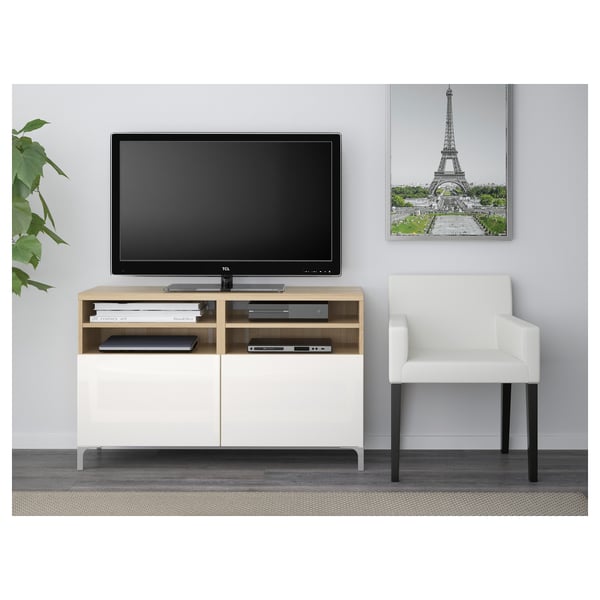 Modern living room with BESTÅ tv stand, flat screen, organised wiring, white armchair, eiffel tower poster.