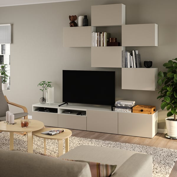 Modern living room with BESTÅ tv storage, books, decor, beige sofa, coffee tables, and house plant.