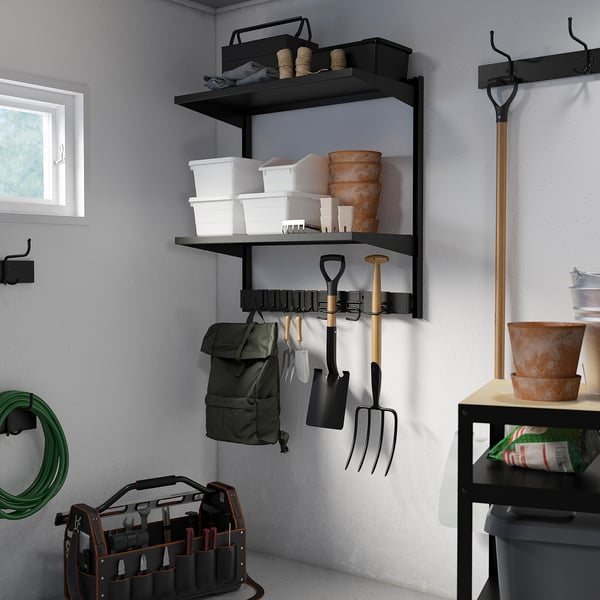 Black metal BROR garden storage with hooks and shelves, holding tools and equipment.