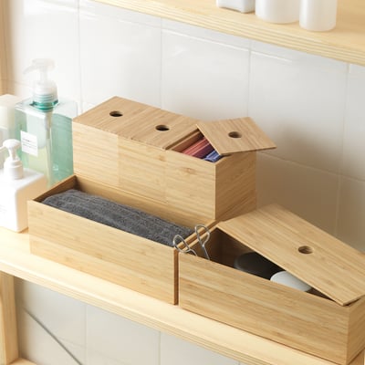 Bamboo boxes on counter: one open, scissors inside, neatly organised.