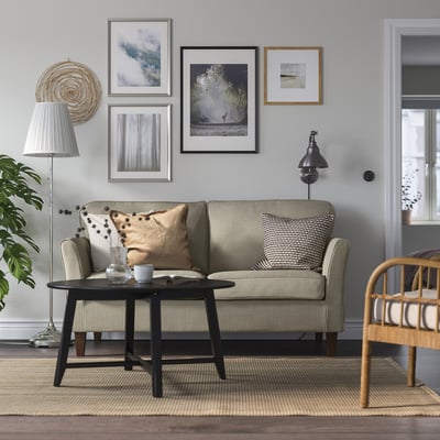 Grey EKHOLMA sofa with throw pillow in cosy living room.
