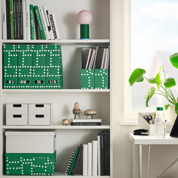 White shelf with green polka-dotted FJÄDERHARV magazine holders holding papers.