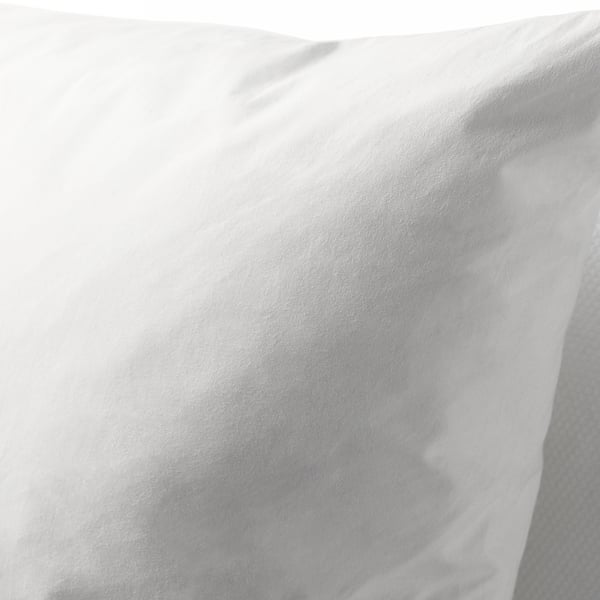 Close-up of a fluffy white feather cushion, showcasing its soft texture and plump filling.