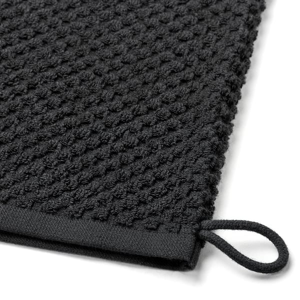 Close-up of black cotton washing mitt; soft, textured, with hanging loop.
