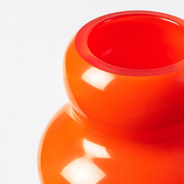 Bright orange glass vase with smooth, glossy finish. Rounded body and narrow opening, displayed prominently against a white background.