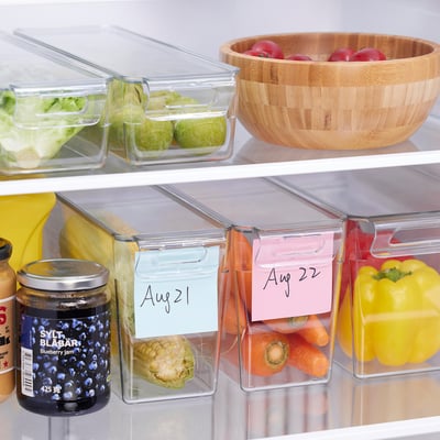 Fridge with organised veggies in stackable containers with date labels.