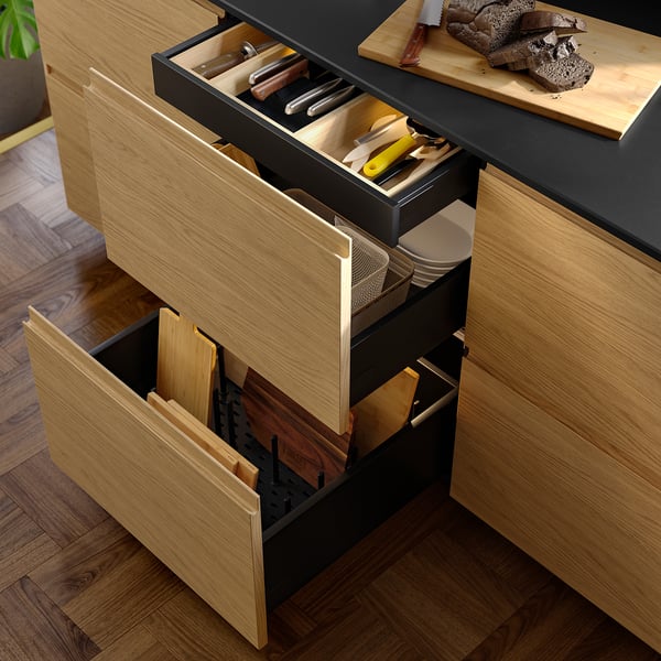 Open wooden kitchen drawer with cutlery, utensils, and pans, showcasing organised compartments and smooth close feature.