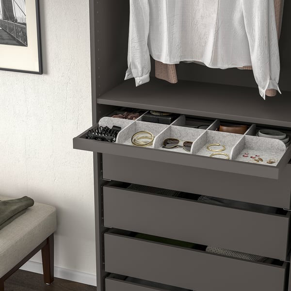 Organised grey drawer unit pulls out for easy access, showing compartments holding jewellery, watches, and small accessories.