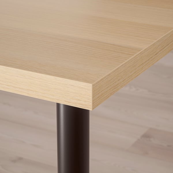 Close-up of a modern, well-finished wooden tabletop with sleek metal legs, showcasing its sturdy and minimalist design.