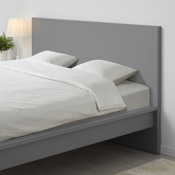 Modern grey MALM bed with crisp white bedding, tall headboard, sleek design.