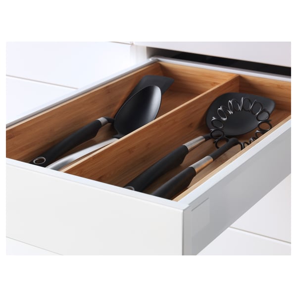 Kitchen drawer with wooden dividers and black utensils.