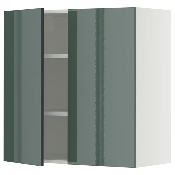Green gloss kitchen cabinet, open door showing shelves.