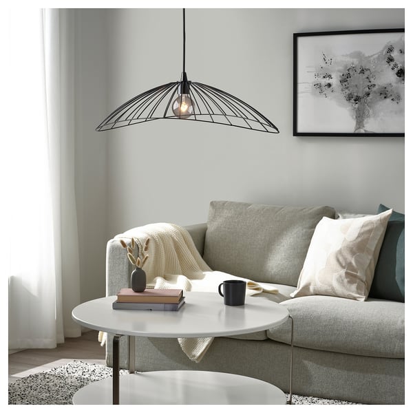 Modern living room with elliptical MOTSJÖ lamp over coffee table with decor.