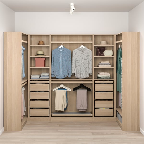 Well-organized wooden PAX closet with hanging shirts, folded clothes, and accessories. Lighting highlights stored items.