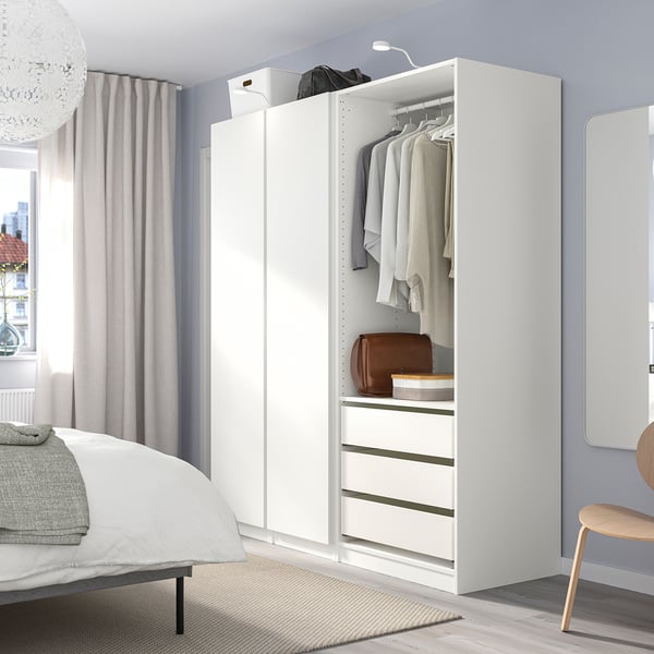 White PAX wardrobe beside bed, minimalist and tidy.