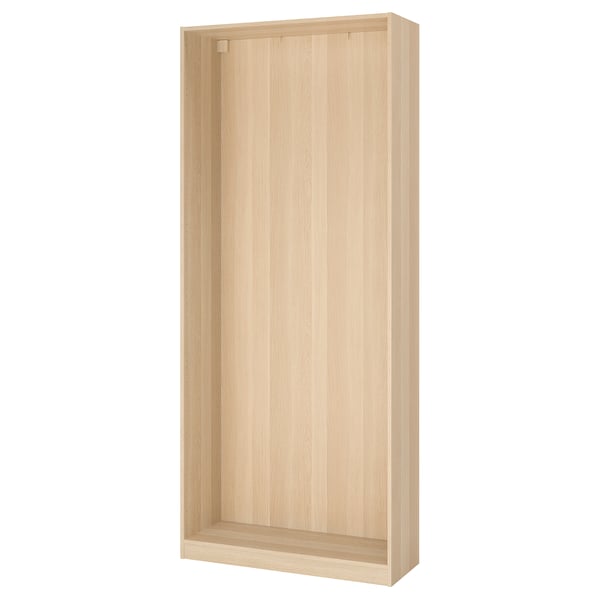 An ikea PAX wardrobe frame, light oak-colored, rectangular, with a minimalist design, made from particleboard and fiberboard.