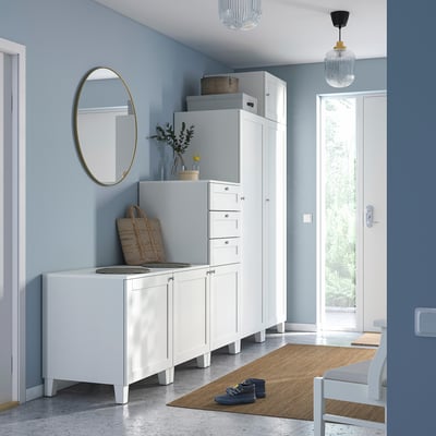 Modern entryway with white PLATSA storage units, mirror, pendant lights, jute rug, and bench, grey walls.