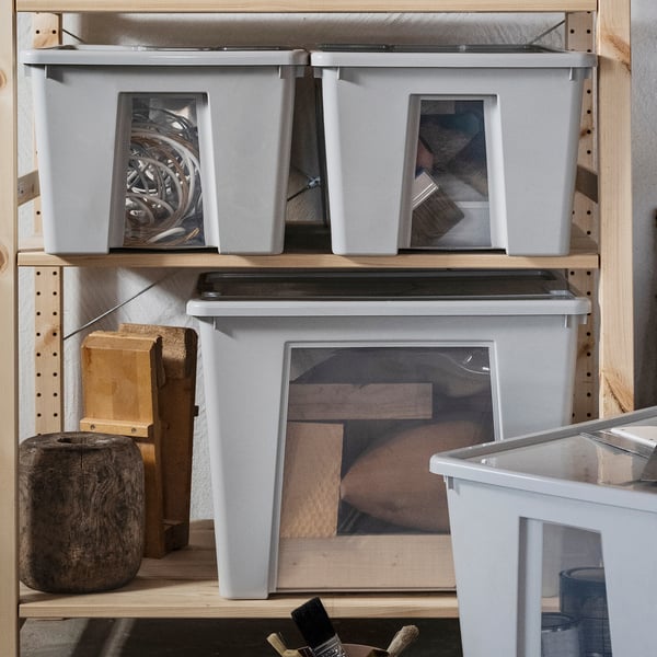 Wooden shelves with SAMLA containers holding tools and items.