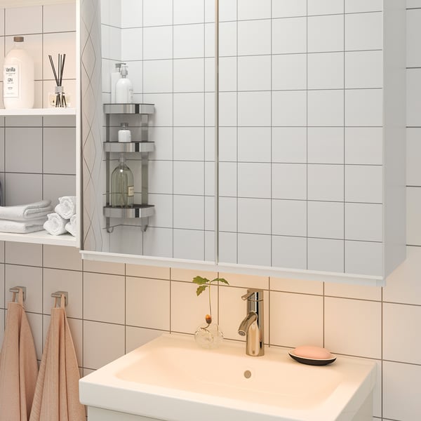 Modern bathroom vanity with led lights, chrome tap, plant vase, soap dish, light tiles.