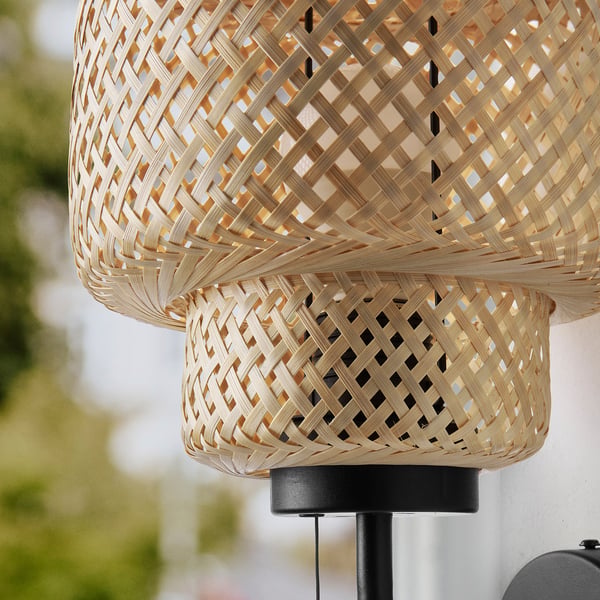 Woven bamboo wall lamps hang from ceiling, emitting soft light with intricate craftsmanship, natural texture, creating cosy atmosphere.