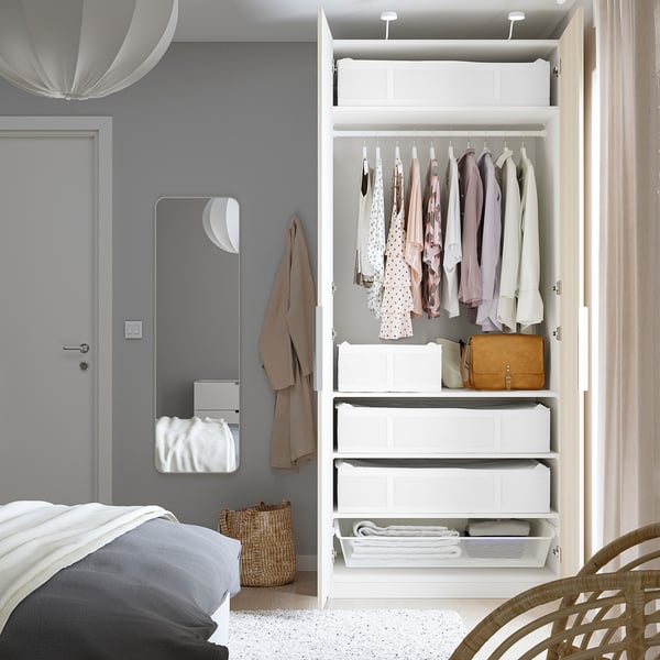 Bedroom closet with clothes, hangers, and SKUBB storage cases.