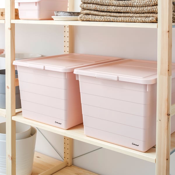 Two pink SOCKERBIT storage boxes with lids on light wooden shelves, stacked neatly for organised storage.