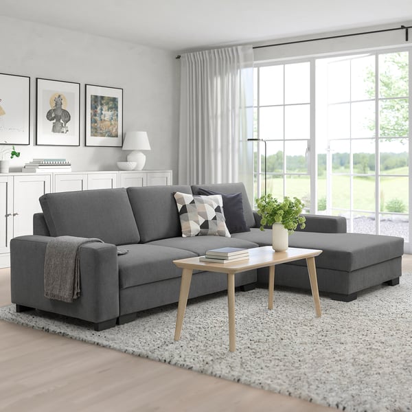 Modern living room with SÖRVALLEN sofa, big windows, rug, coffee table, and throw.