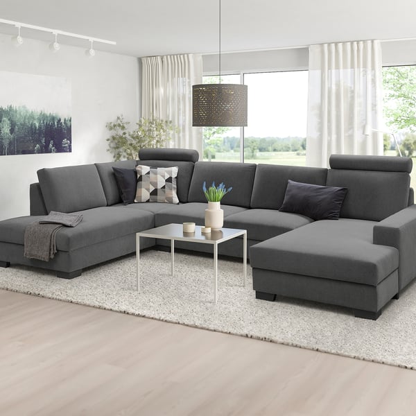 Modern minimalist living room: u-shaped grey SÖRVALLEN sofa, large windows, white rug, white coffee table.
