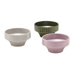 Three colourful ceramic bowls displayed; one beige, one olive green, one light purple, featuring unique outward flaring design.