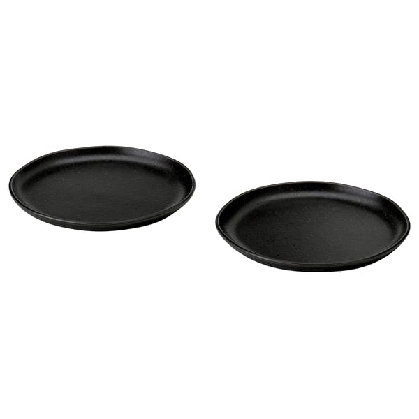 Two black, round, rustic-style side plates with irregular, textured surfaces and matte finish.