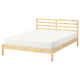 A TARVA light wooden bed frame with a white mattress. The frame is made of solid pine, displaying a simple and modern scandinavian design.