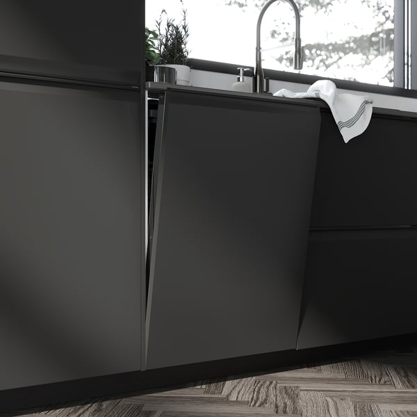 Modern kitchen with sleek, dark cabinets; stainless steel sink, tap, and towel.