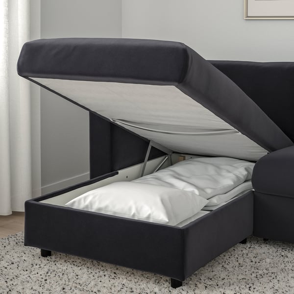 Open sofa-bed with mattress, grey, on speckled rug; ideal for space-efficient homes.