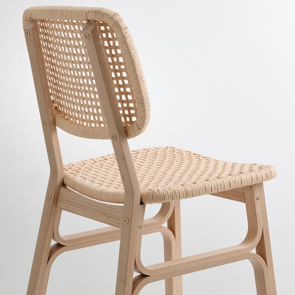 Elegant wicker chair with curved back and seat, expertly woven and durable bamboo frame.
