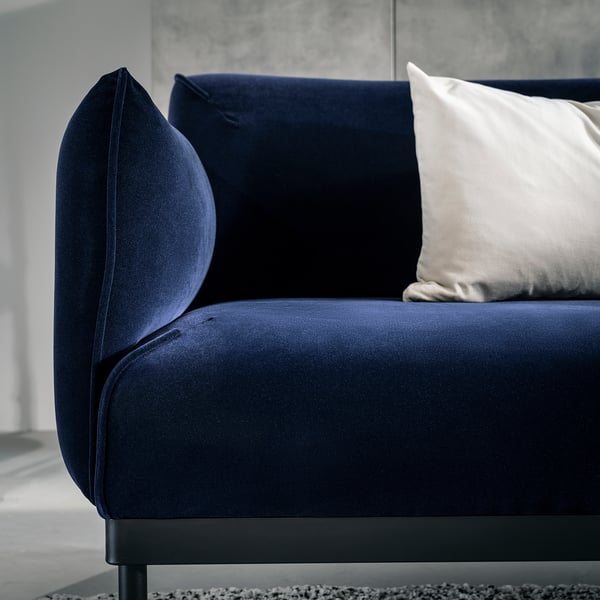 Elegant blue modern sofa with velvet cover, sleek steel feet, and light grey pillows.