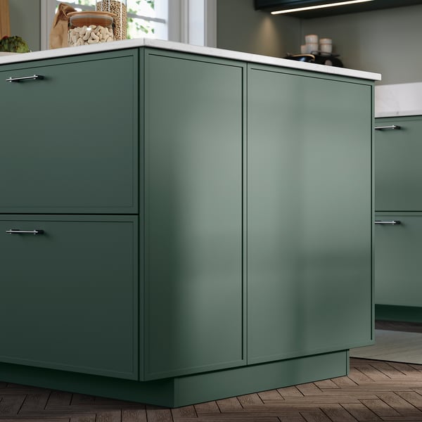Modern kitchen featuring green aspuden cover panels with sleek, thin frames in a dark grey-green shade, adding depth and uniformity to base cabinets.