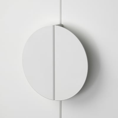 Circular modern handle; sleek, smooth steel finish; attached vertically to wall, high-quality design.
