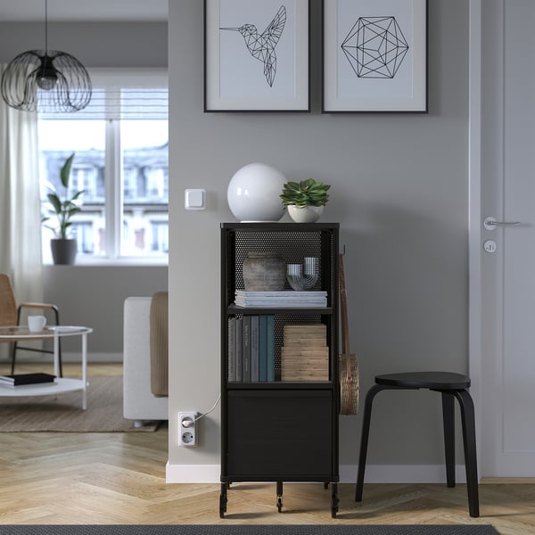Modern room with black BEKANT storage, books, plant, and decor.