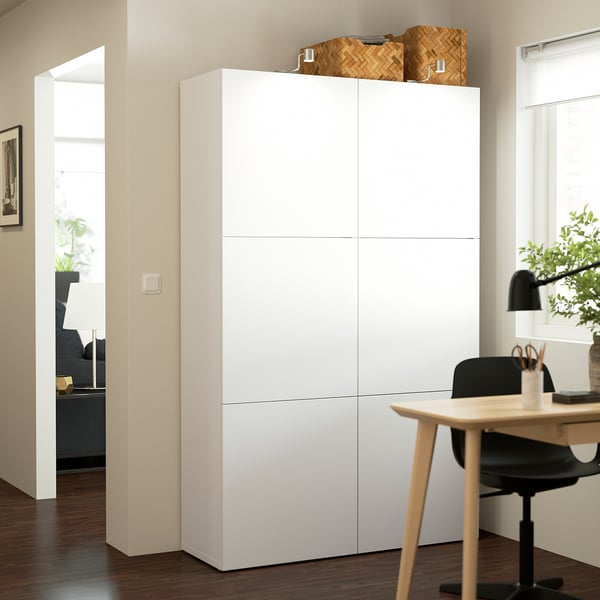 Tall white BESTÅ storage unit in office, larger than desk and chair.