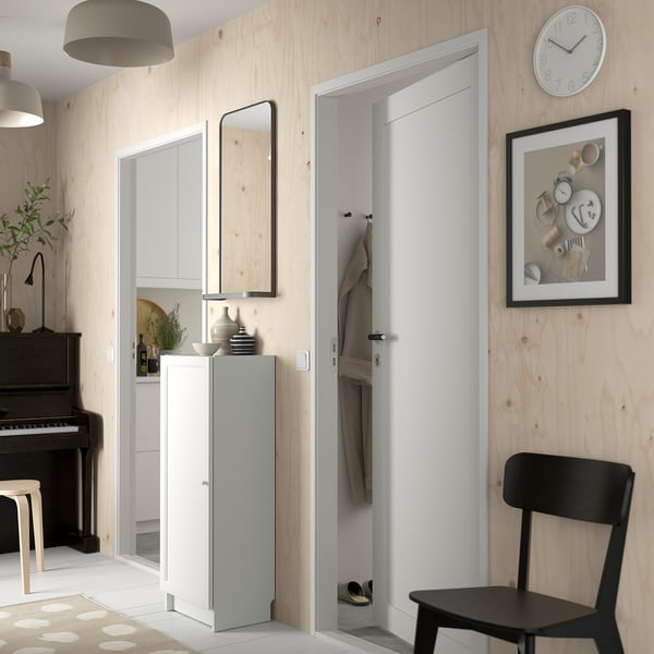 Minimalist entryway with BILLY storage unit, mirror, and decor.