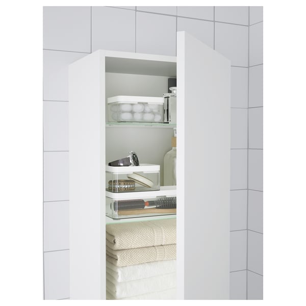 Small bathroom organiser shelves with transparent containers for jewellery, make-up, and folded towels. Keeps items visible and easily accessible.