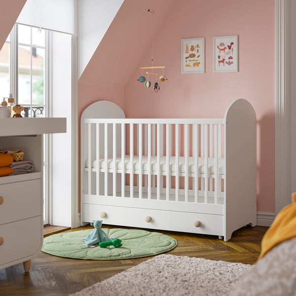 Nursery with white GONATT cot, soft pink walls, and mobile.
