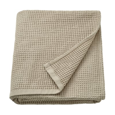 Folded beige towel with waffle texture, neat edges, likely made of recycled cotton.