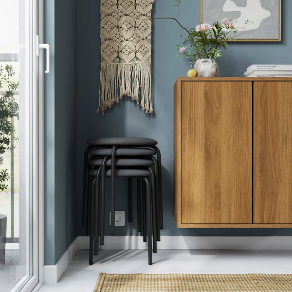 Stackable, padded GULTARP stools by entrance, perfect for extra seating.