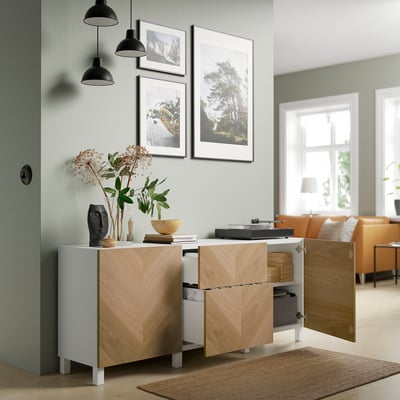 Modern living room with wooden storage, pendant lights, art, and turntable.