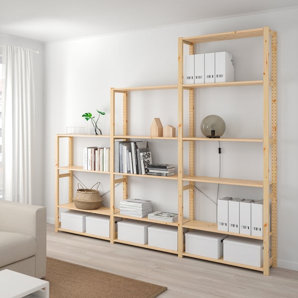 IVAR light wood shelves hold books & boxes, taller than couch, minimalist.
