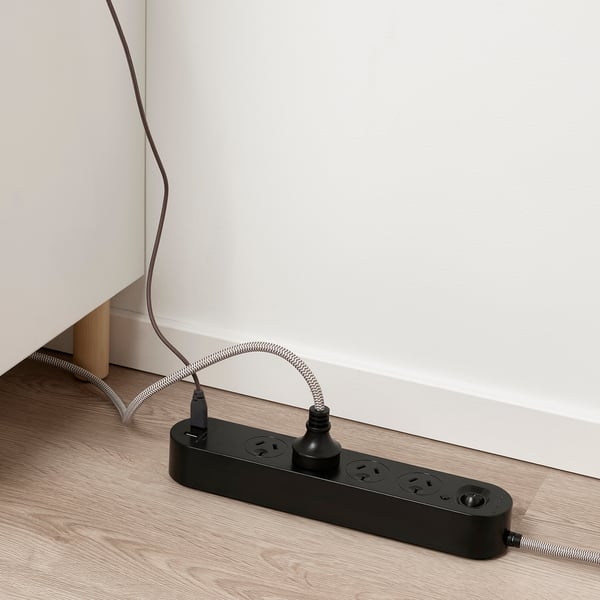 Black multi-socket with usb ports on wooden floor; supplies power to multiple devices.