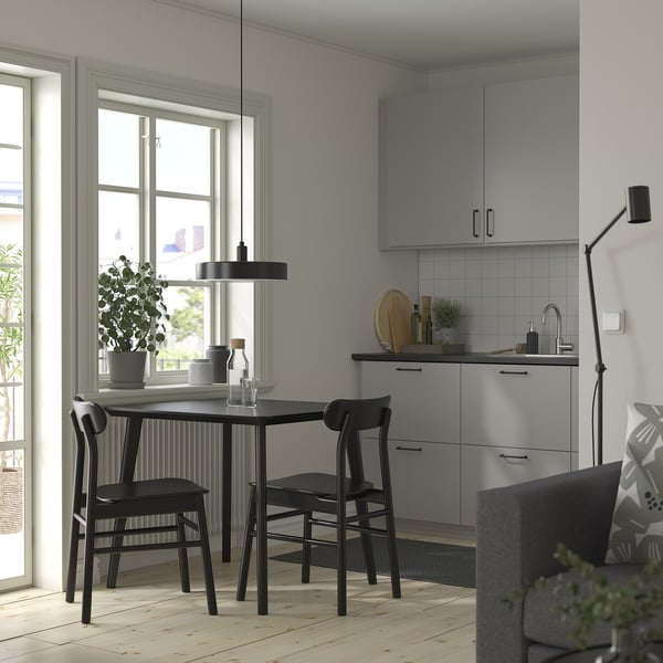 Modern black dining set with square table and minimalist chairs, perfect for small spaces.